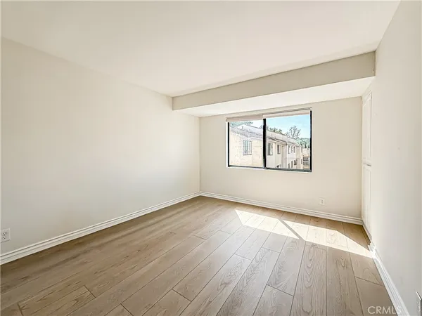 a view of a white house with a large tree