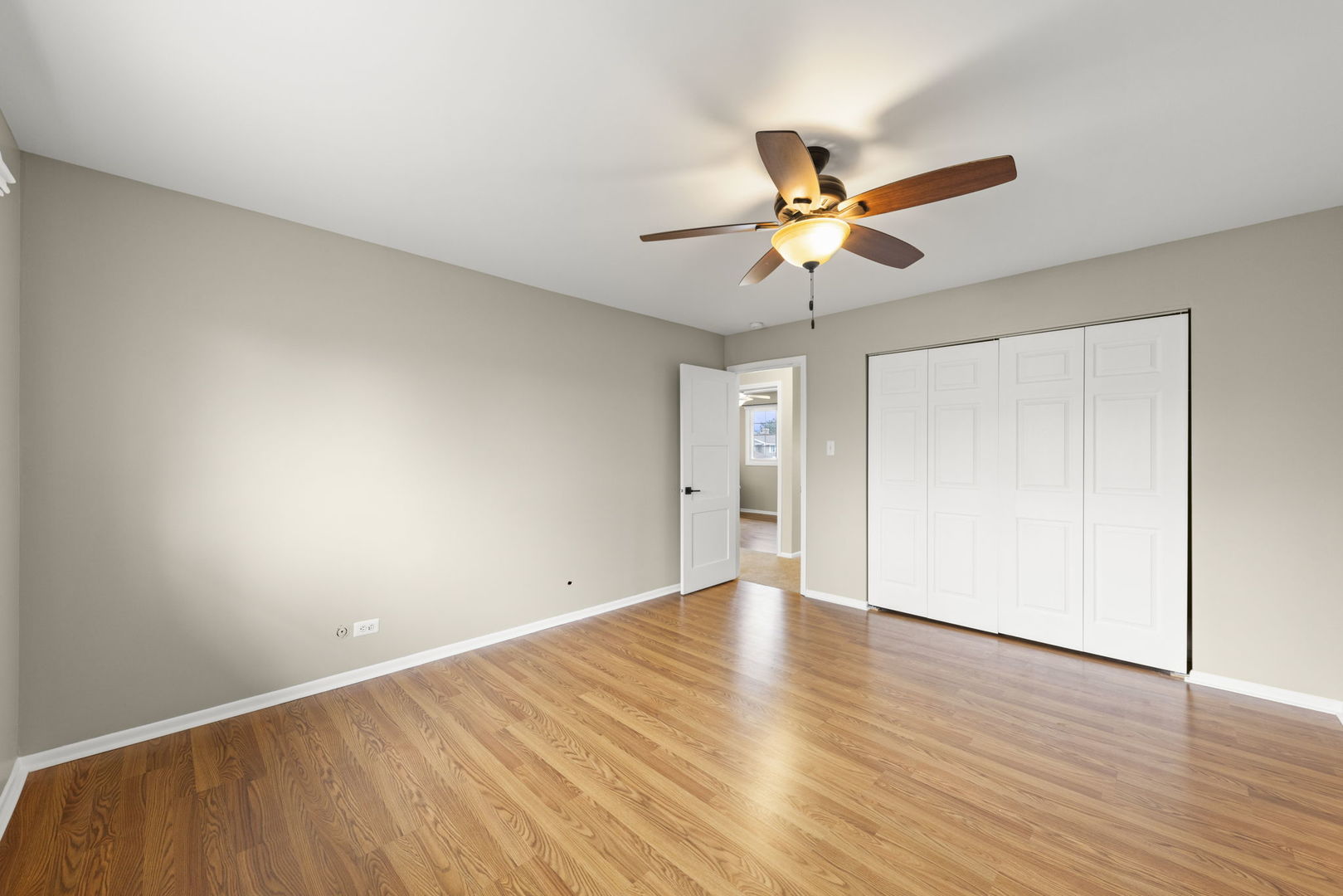 1263 Exeter Court Wheaton, IL 60189 - Photo 14 of 25 an empty room with wooden floor and a ceiling fan