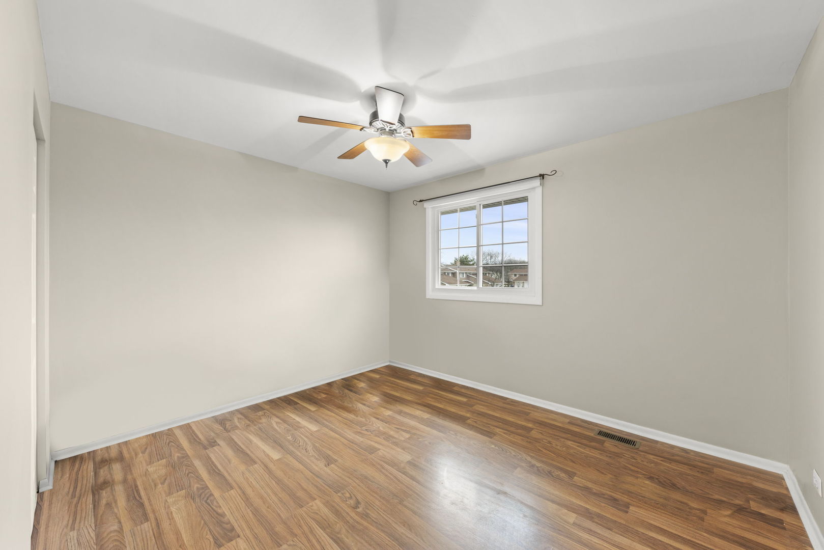 1263 Exeter Court Wheaton, IL 60189 - Photo 17 of 25 an empty room with wooden floor ceiling fan and windows