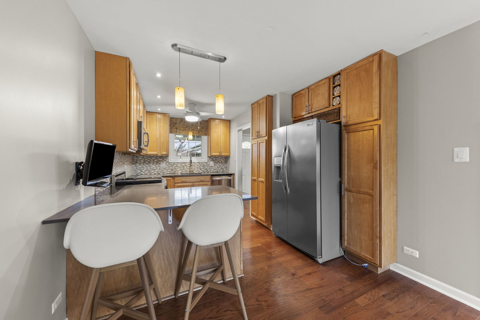 1263 Exeter Court Wheaton, IL 60189 - Photo 5 of 25 a kitchen with stainless steel appliances a refrigerator a sink dishwasher a dining table and chairs with wooden floor