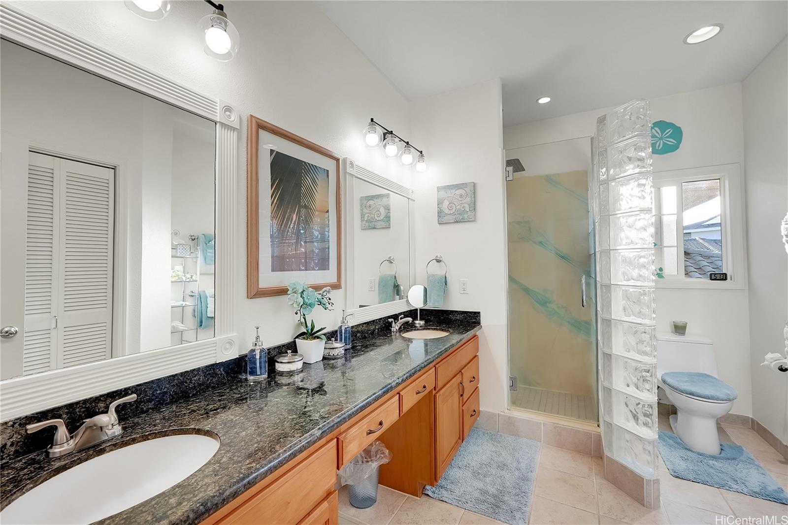 92-1306 Hauone Street Kapolei, HI 96707 - Photo 14 of 25 a bathroom with a granite countertop sink and a large mirror