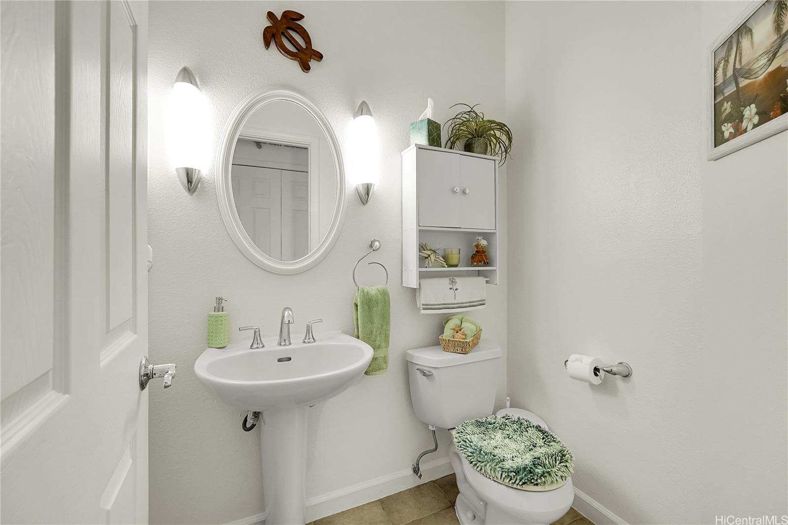 92-1306 Hauone Street Kapolei, HI 96707 - Photo 21 of 25 a bathroom with a toilet sink and mirror