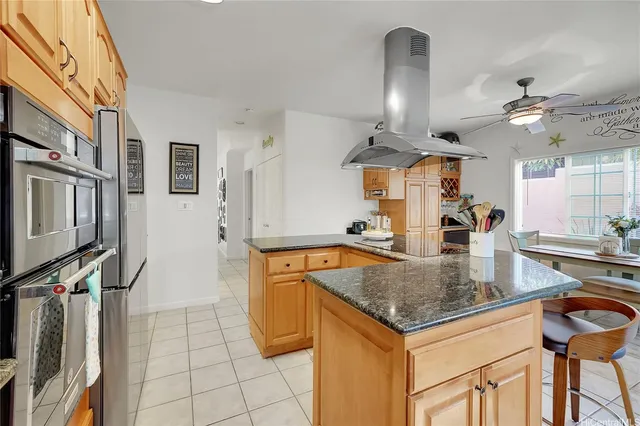 a kitchen with stainless steel appliances granite countertop a sink a stove and a refrigerator