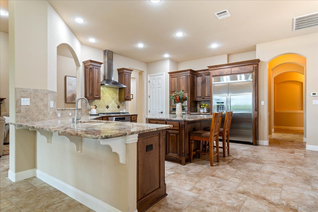3920 Vail Divide Bee Cave, TX 78738 - Photo 11 of 34 a kitchen with stainless steel appliances granite countertop a sink a stove and a dining table