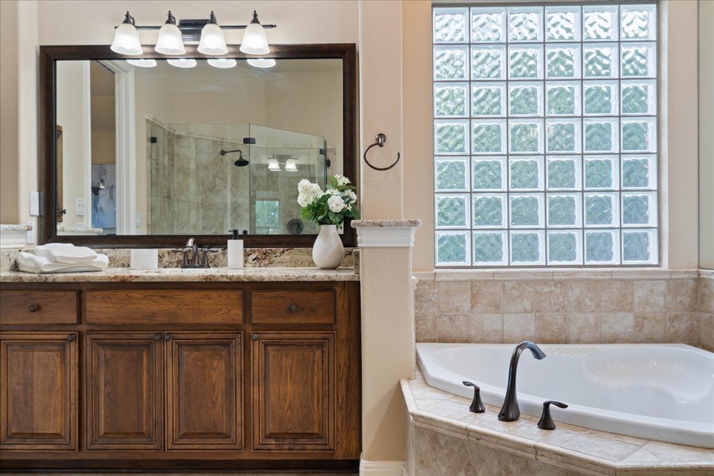 3920 Vail Divide Bee Cave, TX 78738 - Photo 16 of 34 a bathroom with a tub sink and mirror