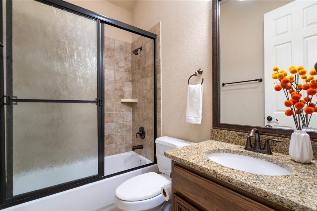 3920 Vail Divide Bee Cave, TX 78738 - Photo 20 of 34 a bathroom with a granite countertop shower sink vanity mirror and toilet