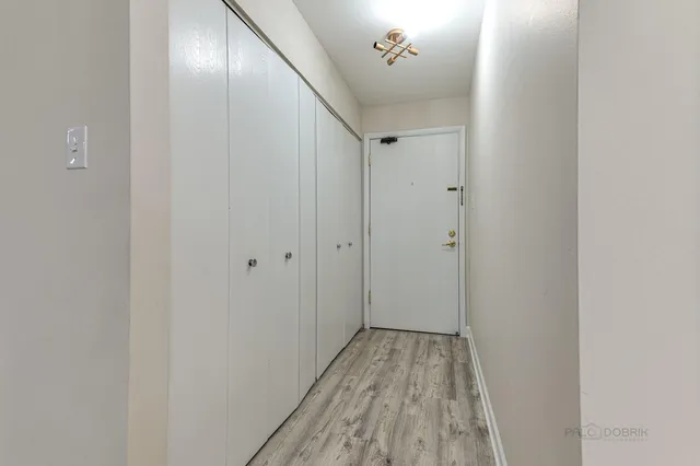 a view of a hallway with wooden floor