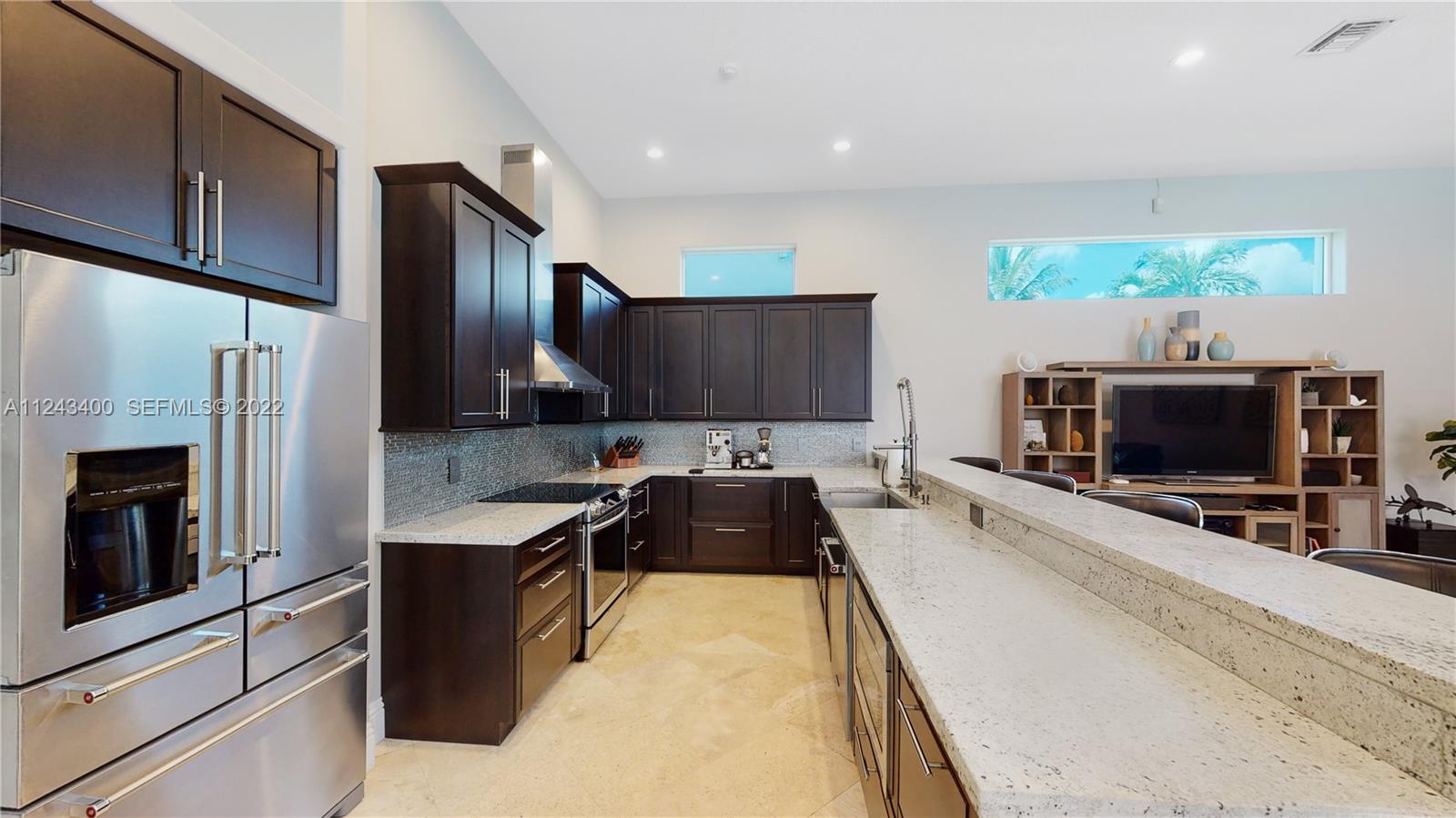 1136 Ginger Circle Weston, FL 33326 - Photo 9 of 32 a kitchen with stainless steel appliances a stove a microwave a sink and a refrigerator