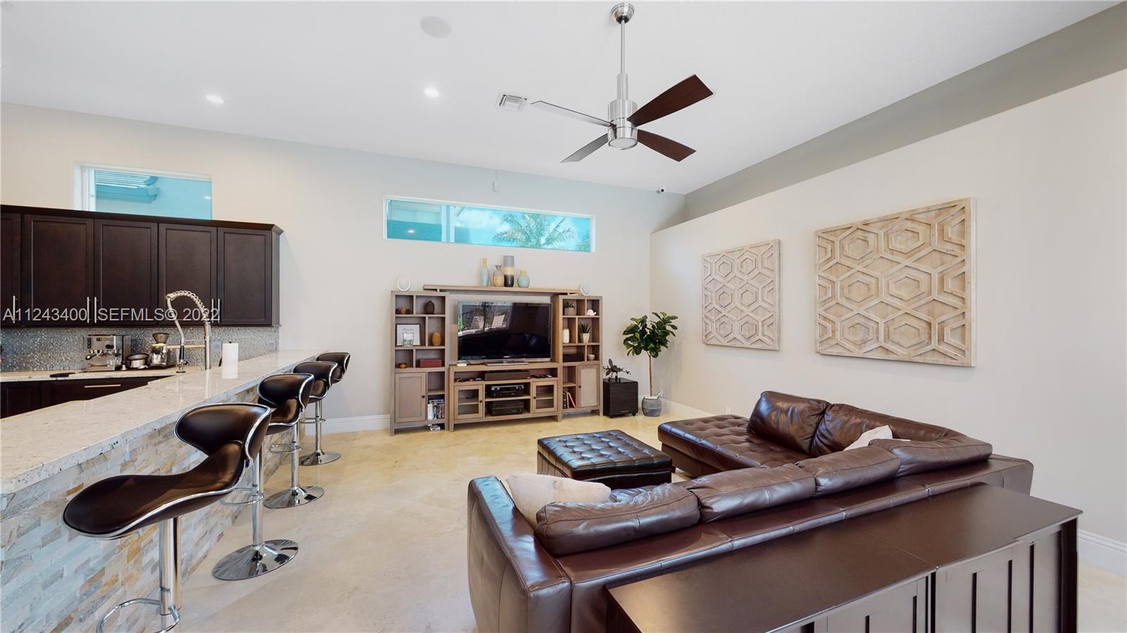1136 Ginger Circle Weston, FL 33326 - Photo 10 of 32 a living room with furniture a flat screen tv and kitchen view