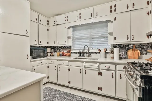 a kitchen with white cabinets and white appliances