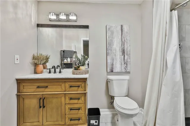 a bathroom with a toilet a sink and mirror