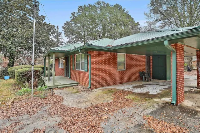 a view of a house with a yard and large tree