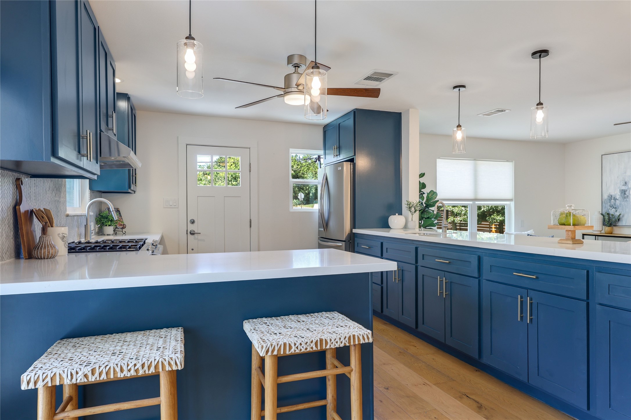 5203 Ledesma Road Austin, TX 78721 - Photo 9 of 40 A vibrant kitchen space showcases rich blue cabinetry and sleek countertops, perfect for entertaining.
