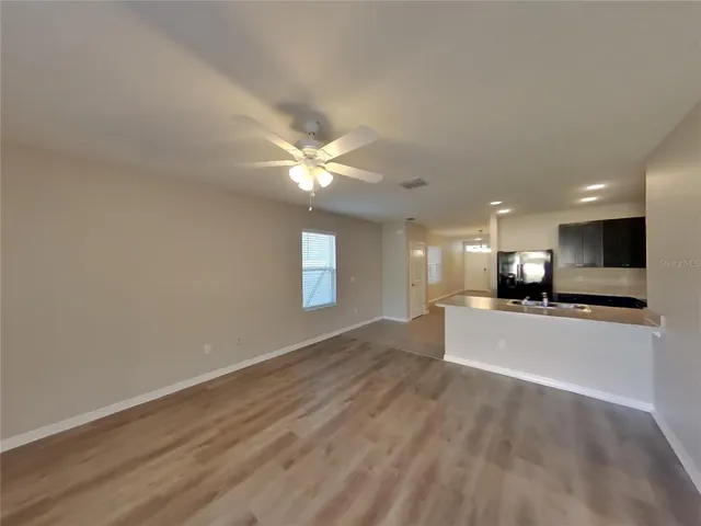a view of a livingroom with a stove wooden cabinets and chandelier