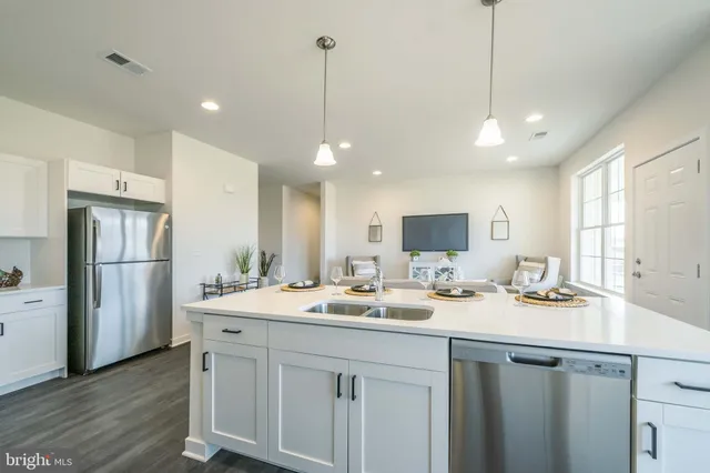 a kitchen with a sink a center island and stainless steel appliances