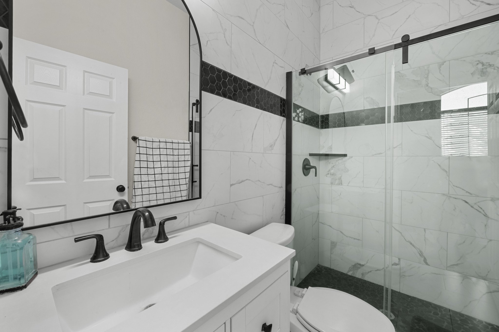 22112 Rock Wren Road Spicewood, TX 78669 - Photo 6 of 40 Bathroom with vanity, a marble finish shower, and tile walls