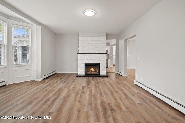 1703 Sanderson Street Scranton, PA 18512 - Photo 7 of 24 a view of empty room with wooden floor and fireplace