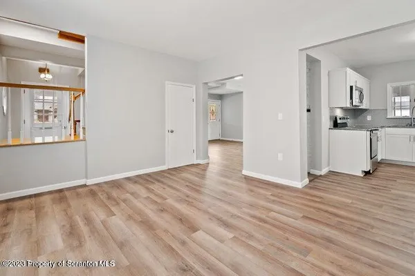 a view of a room with wooden floor and a window