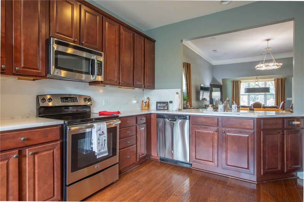 3538 Black Cherry Point Gainesville, GA 30504 - Photo 6 of 44 a kitchen with stainless steel appliances granite countertop wooden cabinets a stove top oven a sink and dishwasher