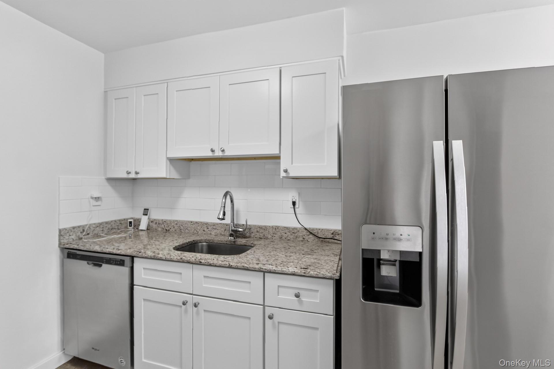 26 Cooper Road, Unit 414 Poughkeepsie, NY 12603 - Photo 14 of 24 Kitchen featuring white shaker cabinetry, stainless steel appliances, granite countertops, a stainless steel sink with gooseneck faucet, and white subway tile backsplash