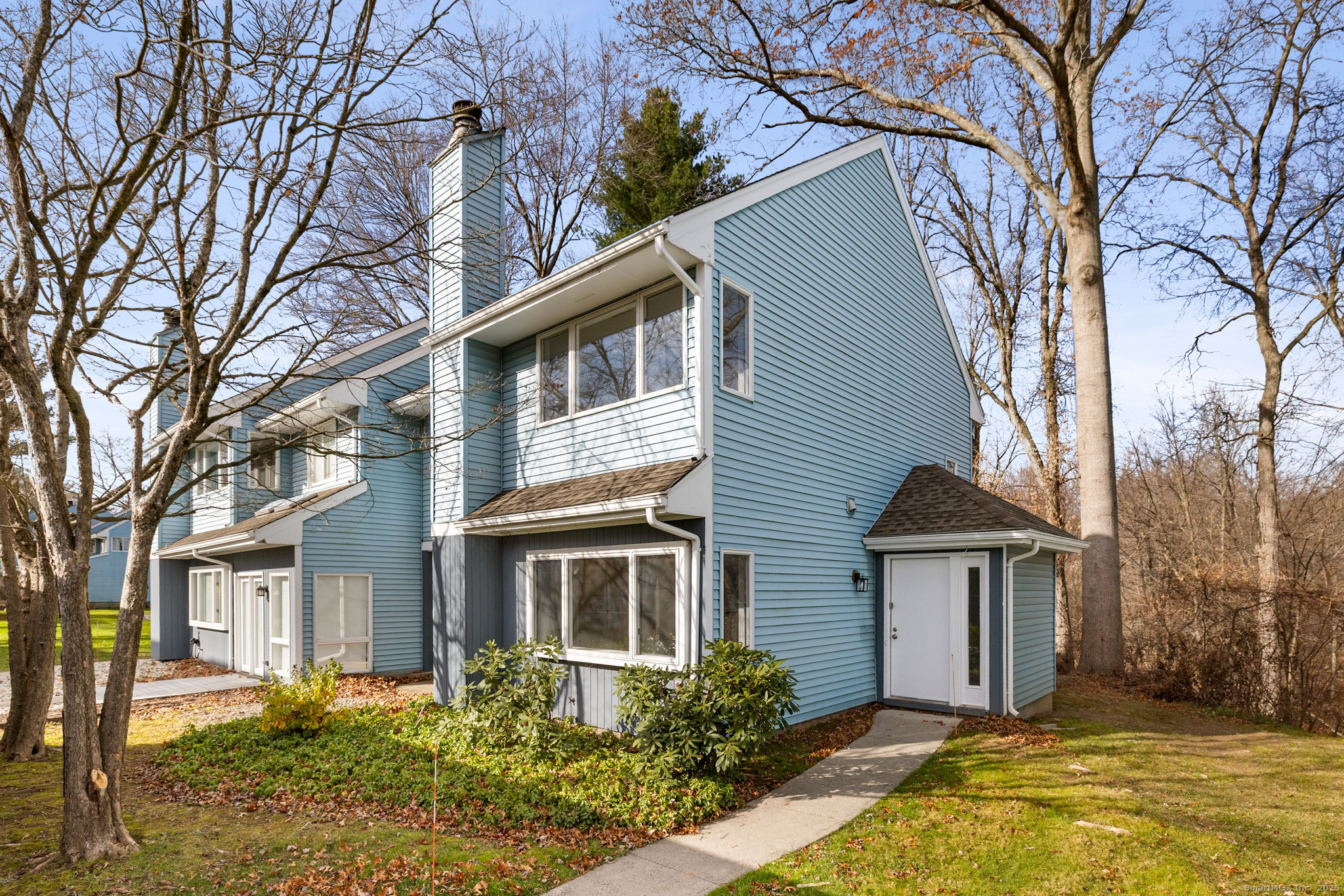 a front view of house with yard and trees around
