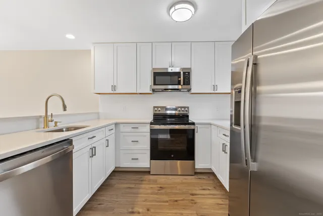 a kitchen with stainless steel appliances granite countertop a refrigerator and a sink