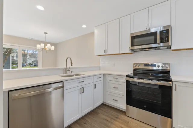 a kitchen with appliances a sink and cabinets