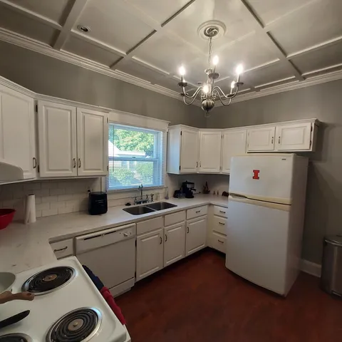 a living room with furniture a chandelier and a flat screen tv