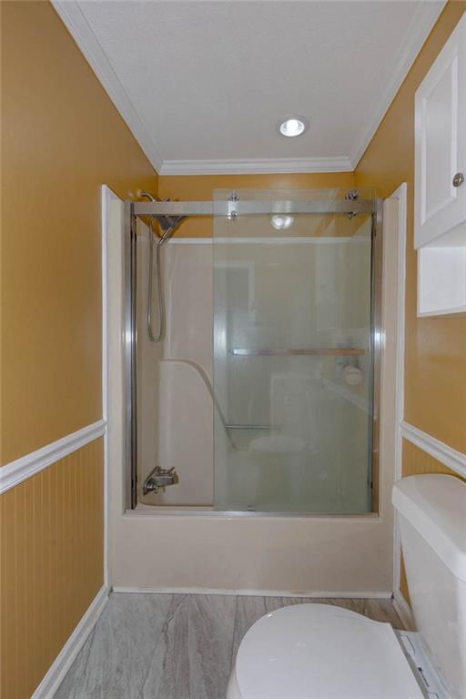 184 Floyd Road Pine Mountain, GA 31822 - Photo 6 of 27 Shower with sliding glass doors, recessed lighting, crown molding, beadboard wainscoting, and wood-finish flooring