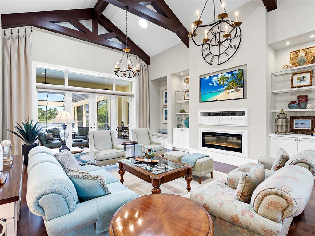 16336 Daysailor Trail Lakewood Ranch, FL 34202 - Photo 16 of 88 a living room with furniture a fireplace and a chandelier