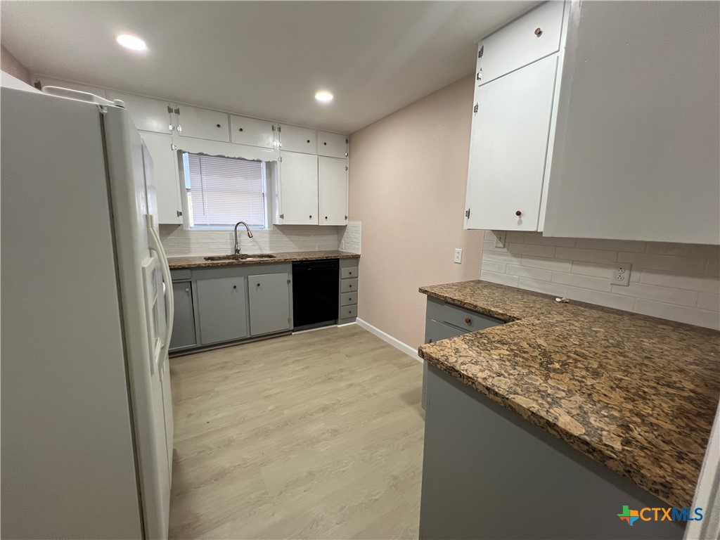 1009 Oak Street Refugio, TX 78377 - Photo 5 of 22 a kitchen with stainless steel appliances granite countertop a stove a sink and a refrigerator