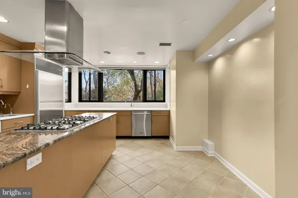 a large white kitchen with a stove and a refrigerator