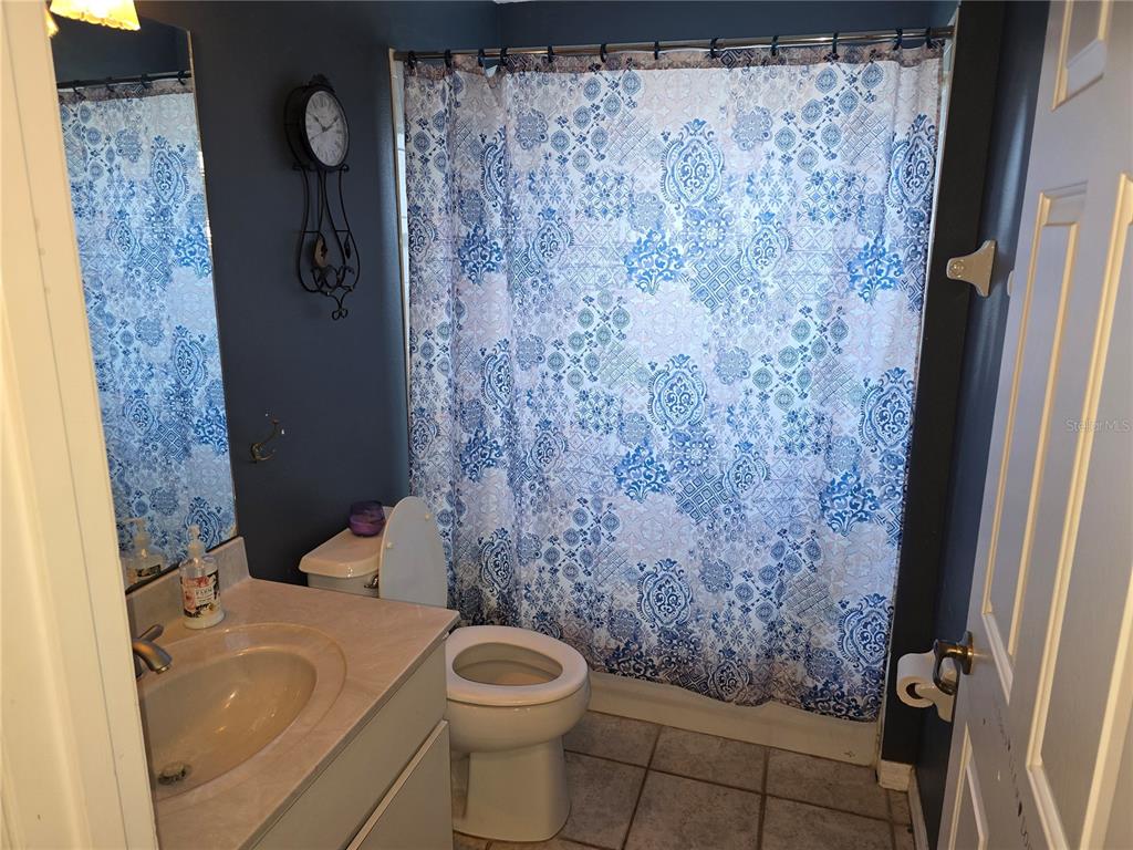 5904 Southwest 107th Street Ocala, FL 34476 - Photo 18 of 33 a bathroom with a toilet and a shower curtain