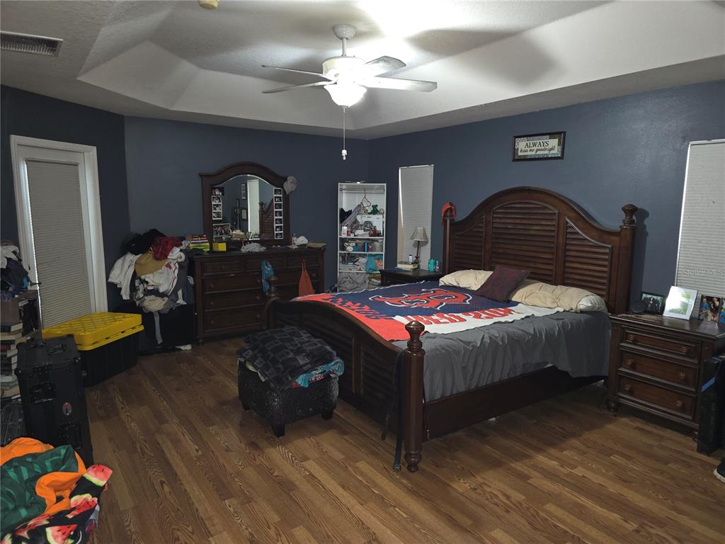 5904 Southwest 107th Street Ocala, FL 34476 - Photo 29 of 33 a bedroom with a bed dresser flowerpot and window