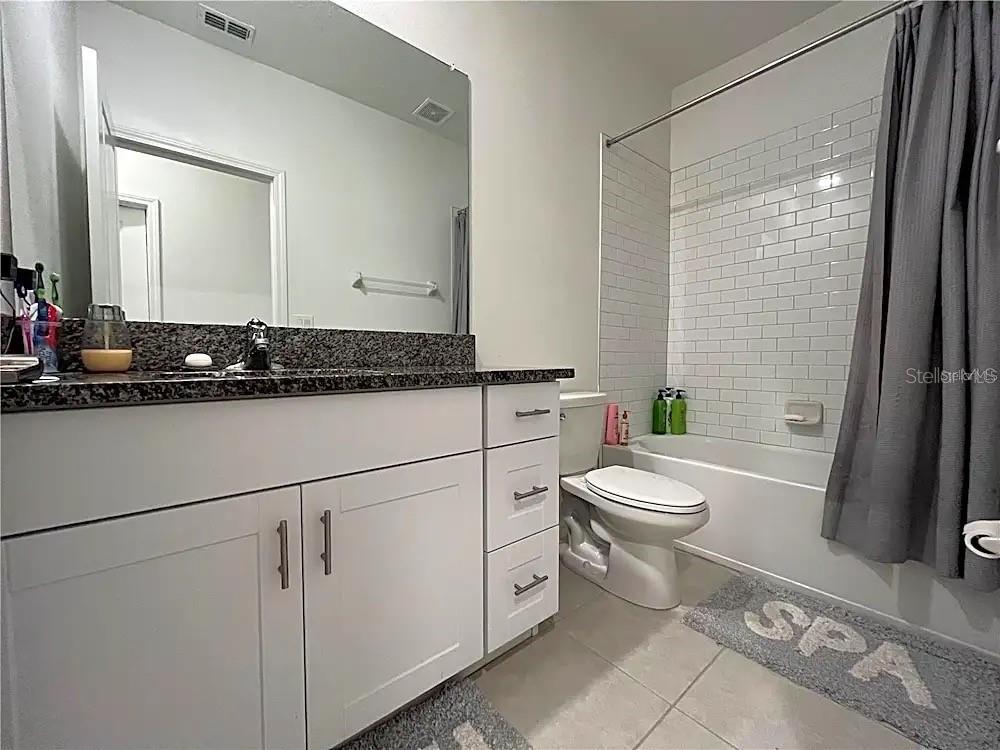 31751 Blue Passing Loop Wesley Chapel, FL 33545 - Photo 12 of 18 a bathroom with a granite countertop sink mirror vanity and toilet