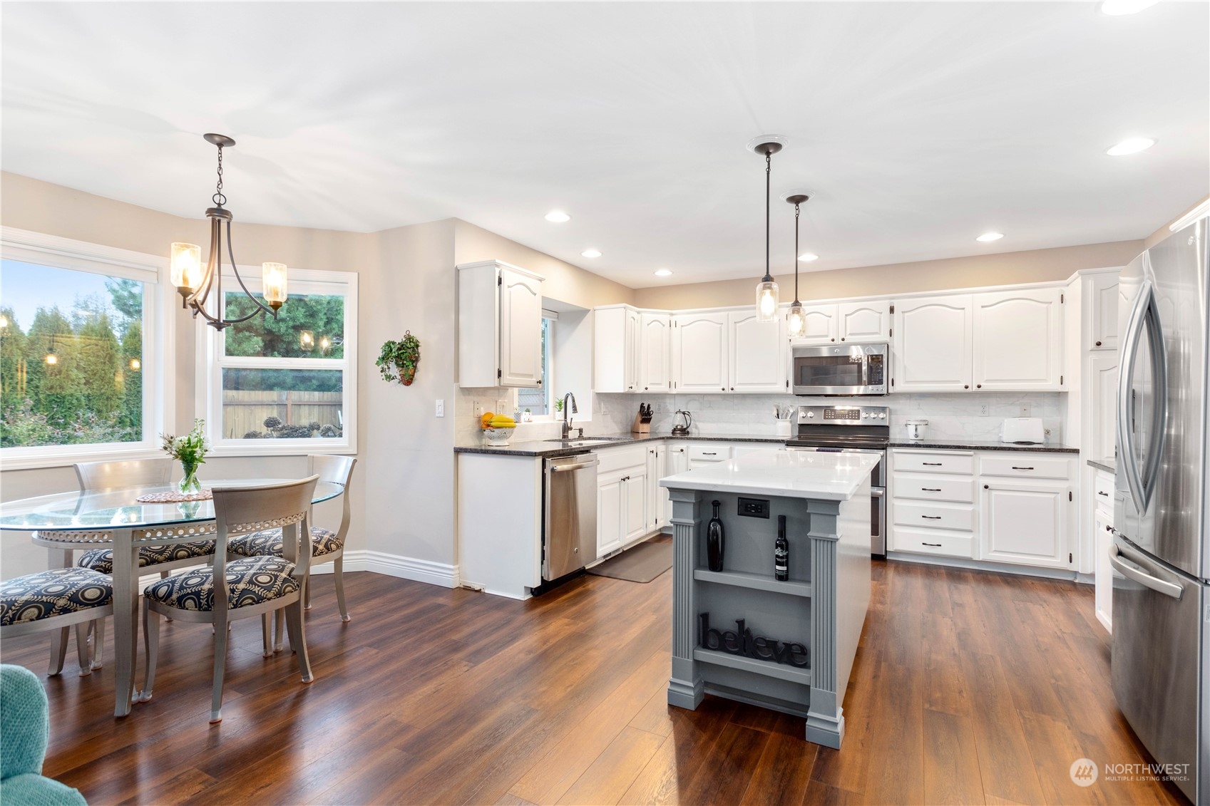 212 Springview Drive Lynden, WA 98264 - Photo 8 of 40 a kitchen with a center island appliances wooden floor and cabinets