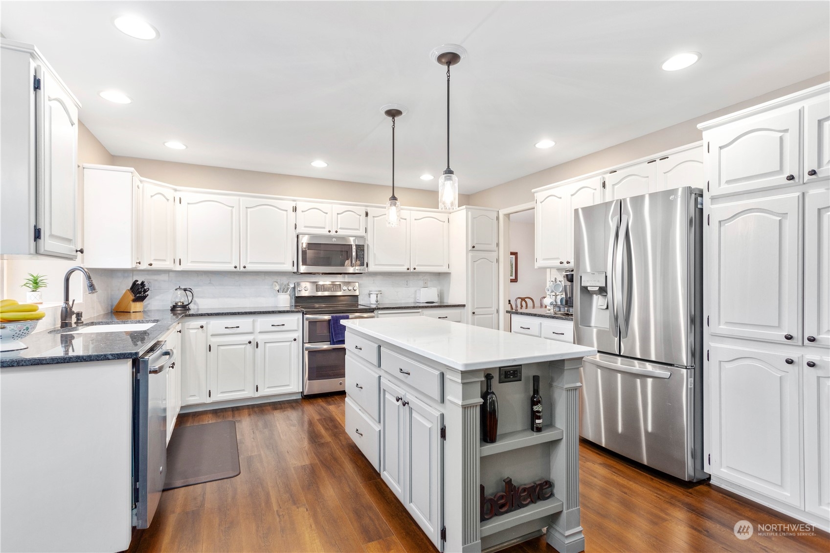 212 Springview Drive Lynden, WA 98264 - Photo 9 of 40 a kitchen with a white center island cabinets and stainless steel appliances