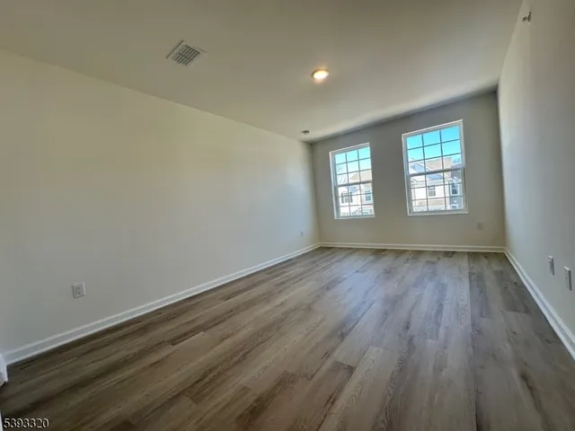 an empty room with wooden floor and window