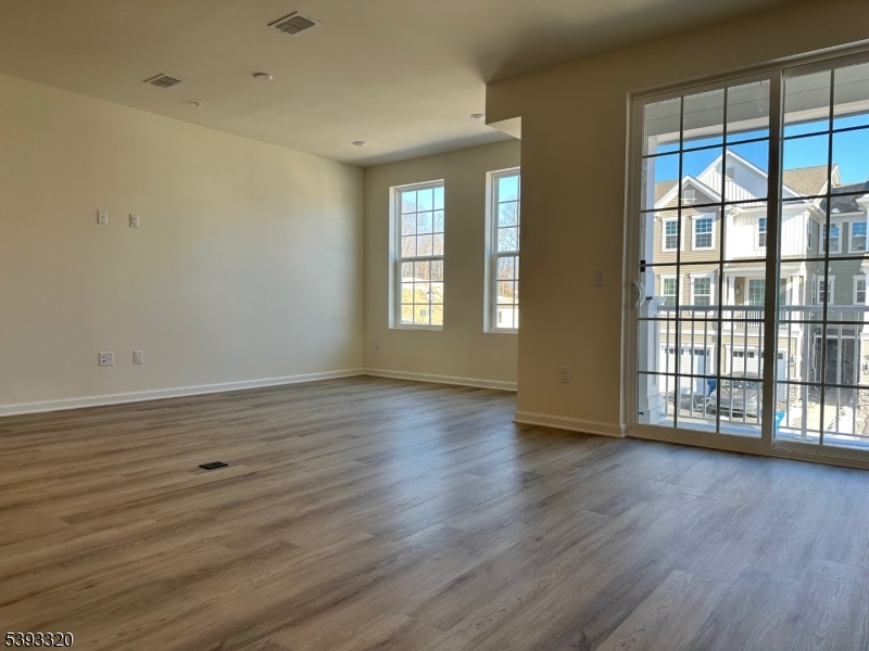 203 Honeysuckle Lane Warren, NJ 07059 - Photo 3 of 22 a view of an empty room with wooden floor and a window