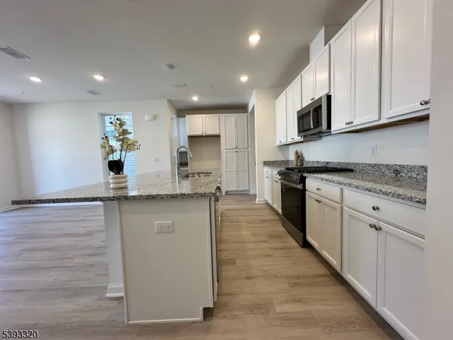 a kitchen with stainless steel appliances granite countertop a stove a sink and a microwave