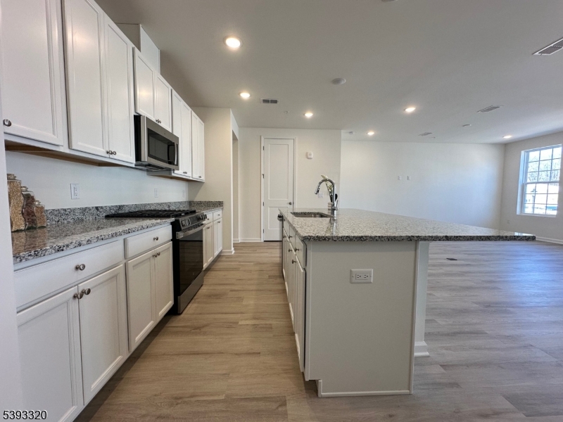 203 Honeysuckle Lane Warren, NJ 07059 - Photo 6 of 22 a kitchen with granite countertop white cabinets and stainless steel appliances