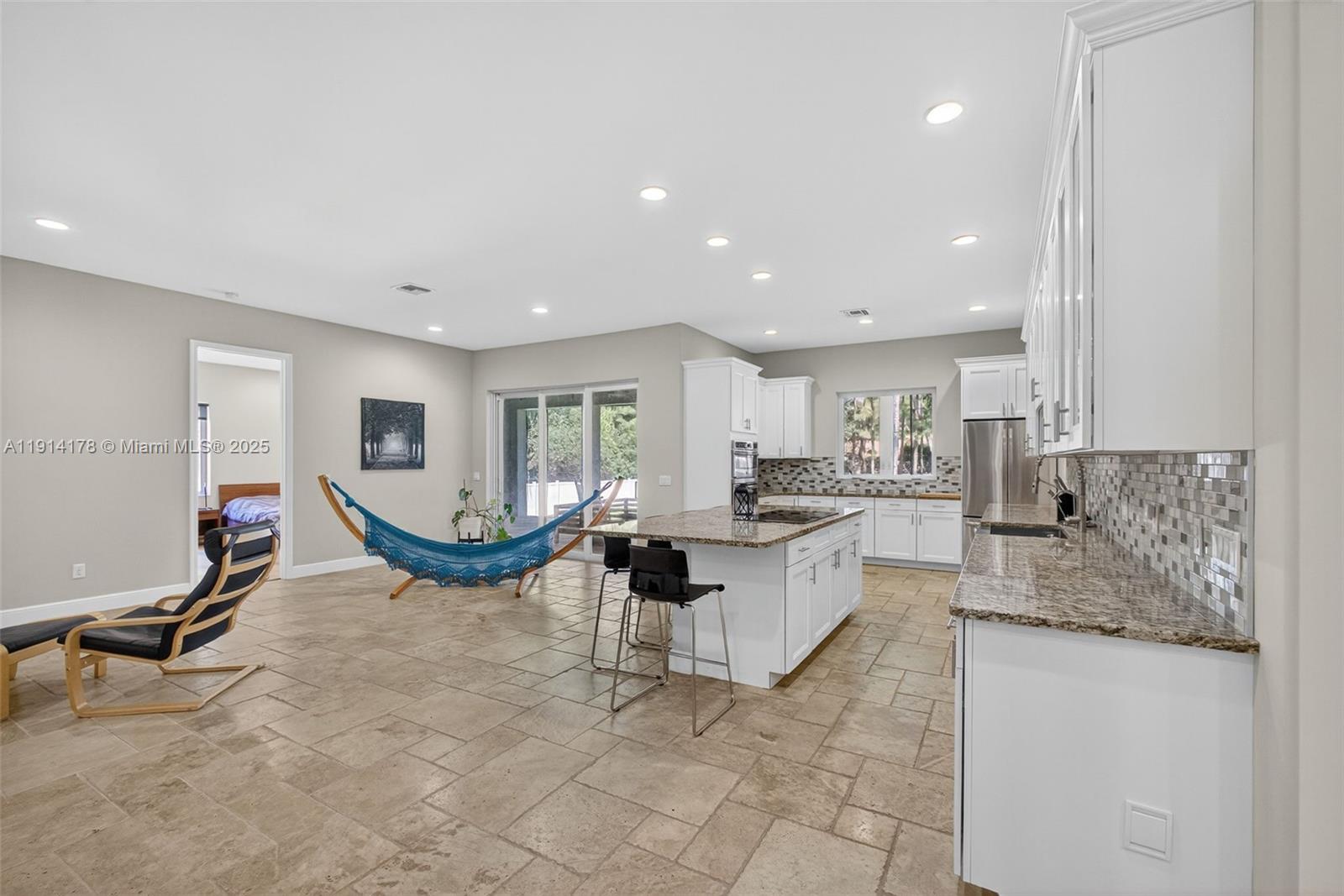 18369 Mellen Lane Jupiter, FL 33478 - Photo 15 of 84 a living room with patio furniture and a large window
