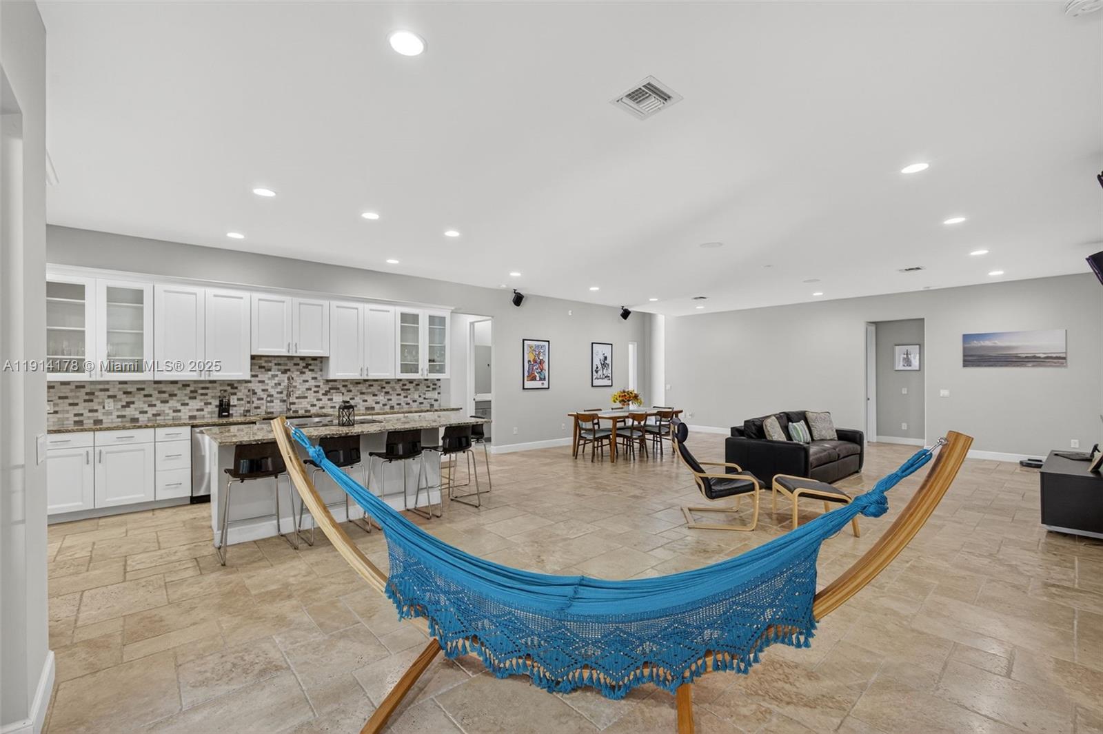 18369 Mellen Lane Jupiter, FL 33478 - Photo 19 of 84 a kitchen with stainless steel appliances granite countertop a stove a sink a dining table and chairs