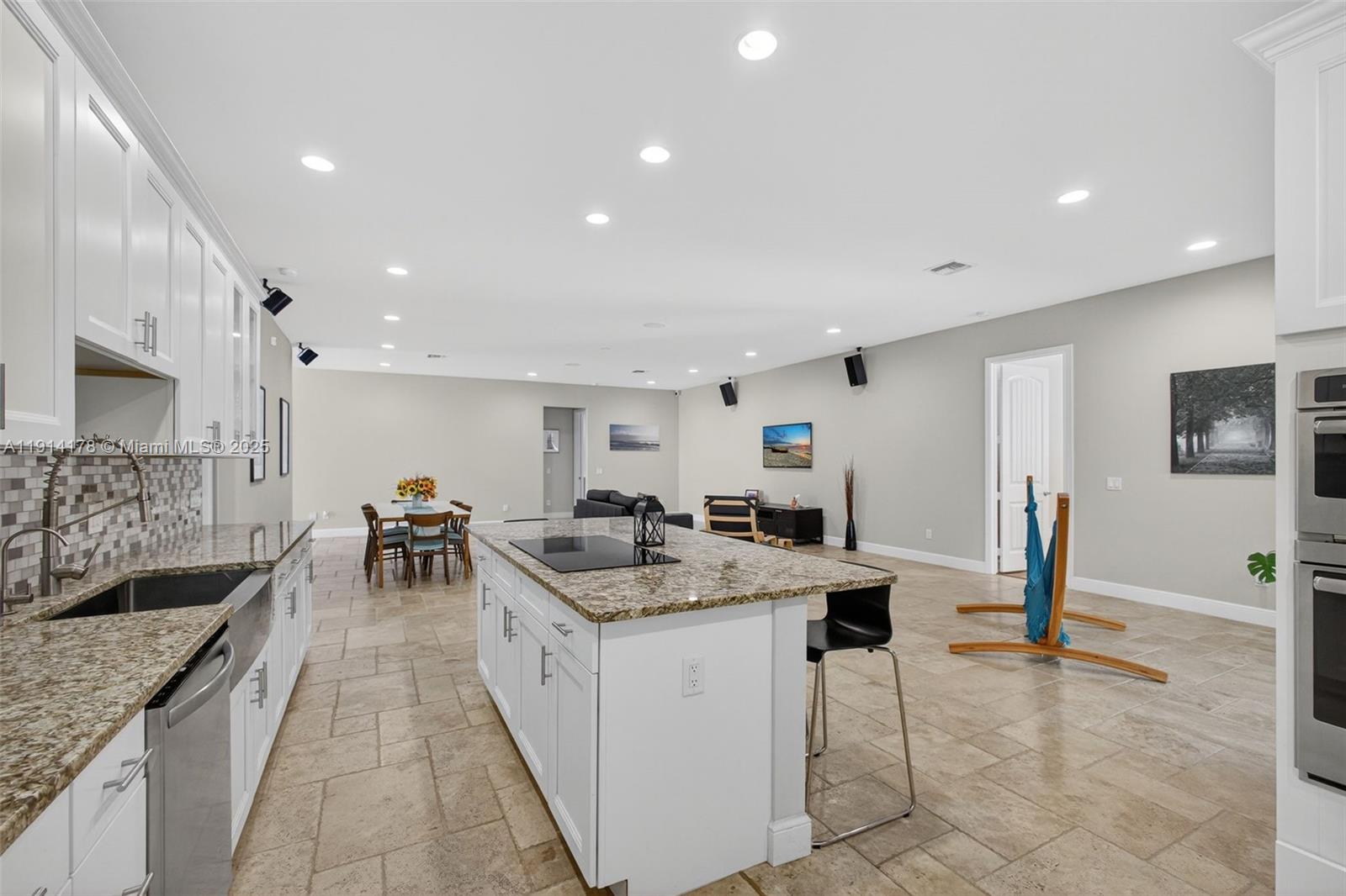 18369 Mellen Lane Jupiter, FL 33478 - Photo 24 of 84 a kitchen with stainless steel appliances kitchen island granite countertop a sink and cabinets