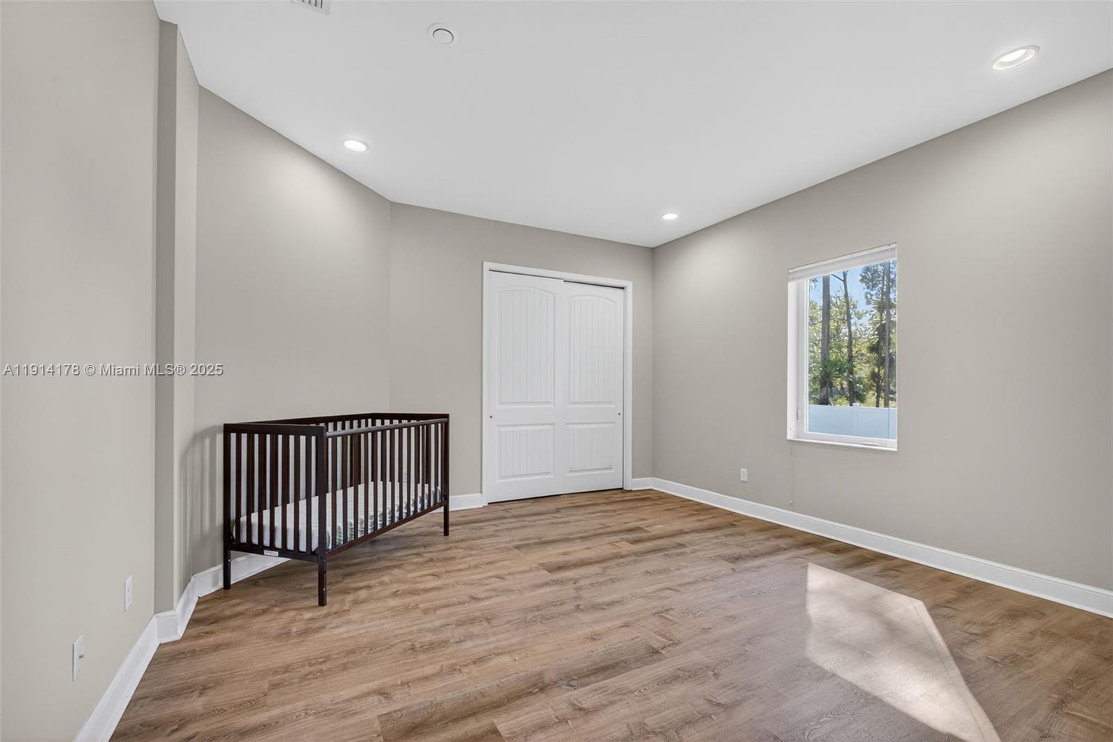 18369 Mellen Lane Jupiter, FL 33478 - Photo 36 of 84 a view of an empty room with wooden floor and a window