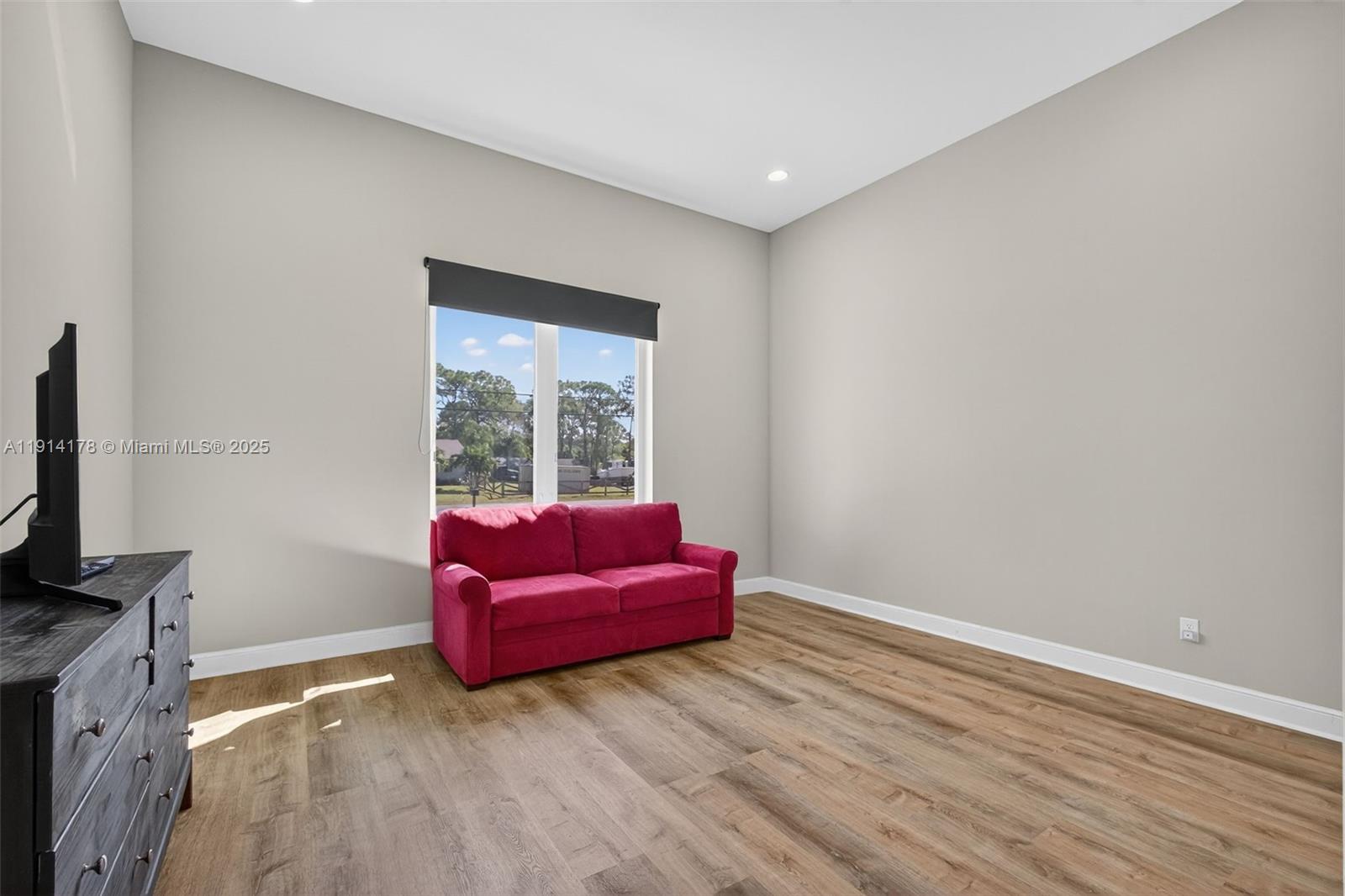 18369 Mellen Lane Jupiter, FL 33478 - Photo 45 of 84 a room with furniture and a flat screen tv