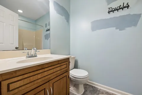 a bathroom with a toilet a sink and mirror