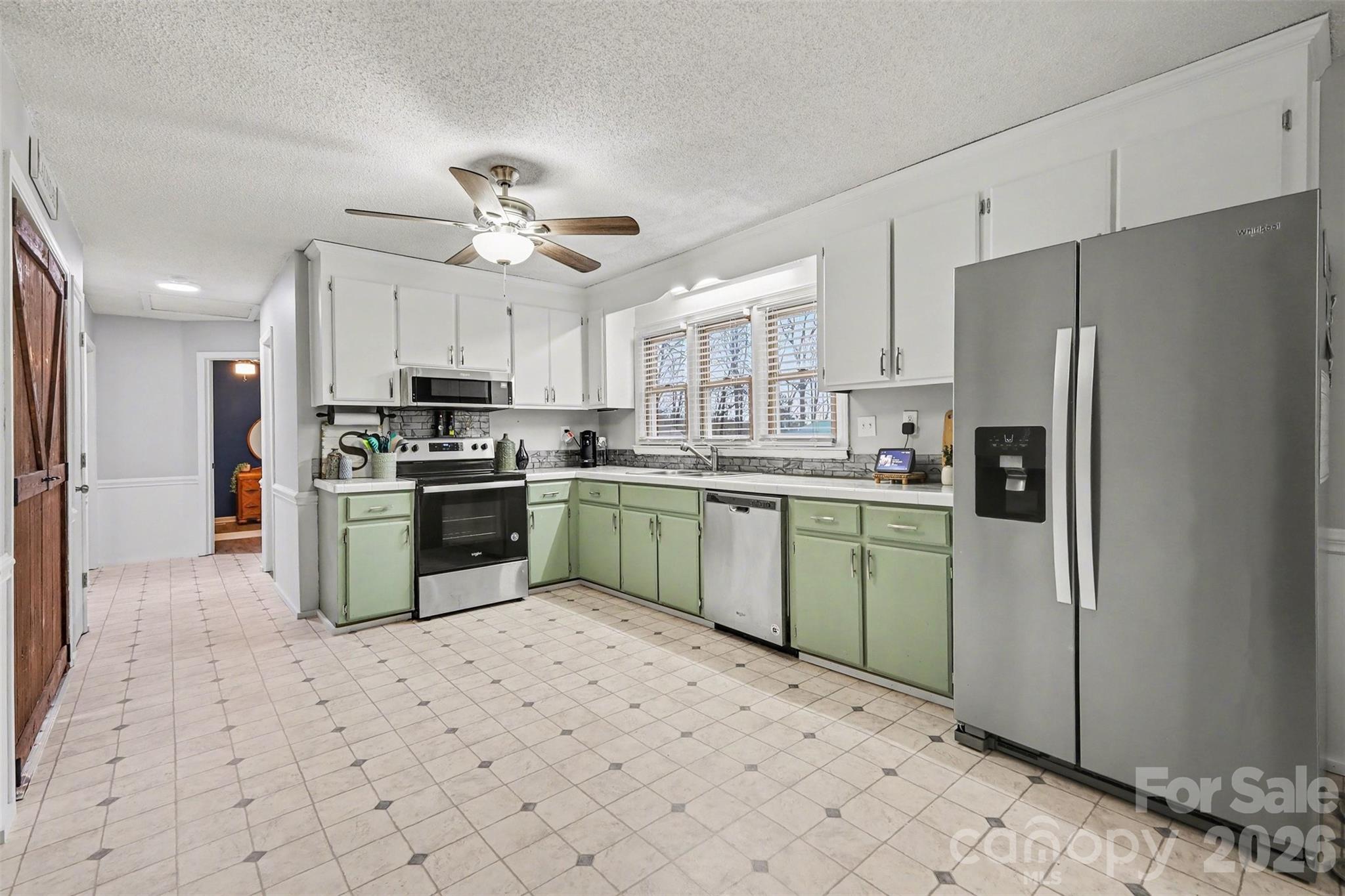 1008 Edgewood Road Bessemer City, NC 28016 - Photo 13 of 26 a kitchen with a sink a refrigerator and white cabinets