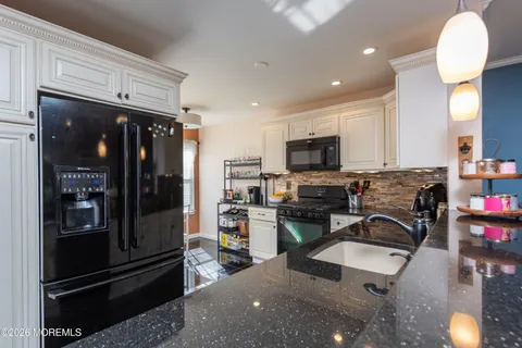 a kitchen with granite countertop a refrigerator and a stove top oven