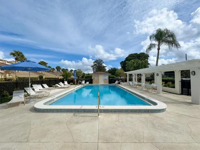 a view of a patio with a table and chairs under an umbrella